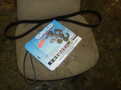 1996 Ford Probe - A Dayco automotive timing belt is shown with its packaging, resting on a chair.