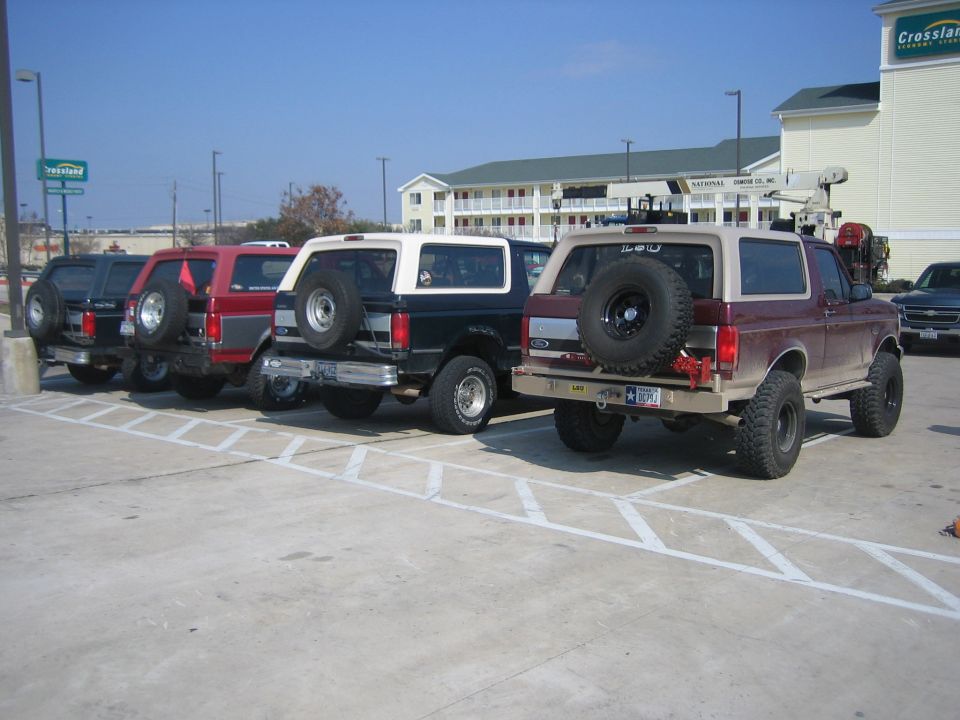 Maroon 1996 Ford Bronco with spare tire on rear, parked in lot