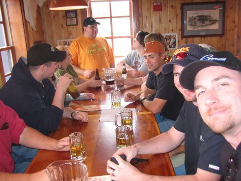 1996 Ford Bronco - Friends gather around a table in a wood-paneled room, enjoying drinks and conversation.