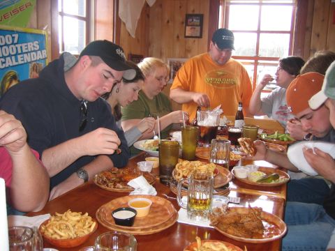 1996 Ford Bronco - A group of people are gathered around a table, enjoying a meal with various food and drinks.