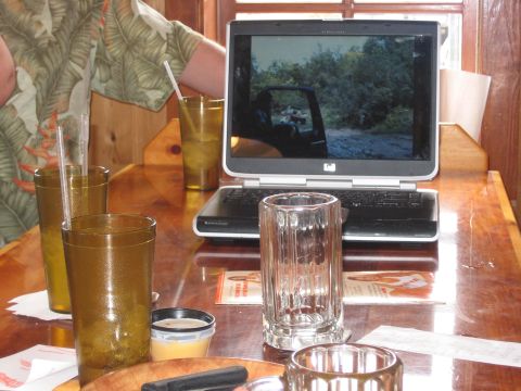 1996 Ford Bronco - A laptop displays a vehicle on a dirt road, with drinks and a person's arm visible in the foreground.