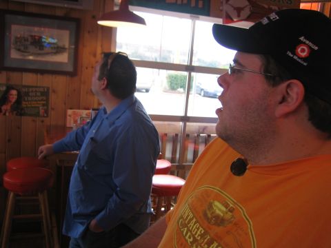 1996 Ford Bronco - Two men are looking up in a bar, one wearing a blue shirt and the other an orange shirt with a baseball cap.