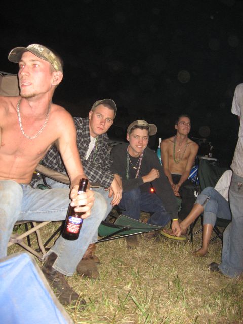 1974 Ford F-100 - Several young men are gathered outdoors at night, seated in camping chairs and holding drinks.