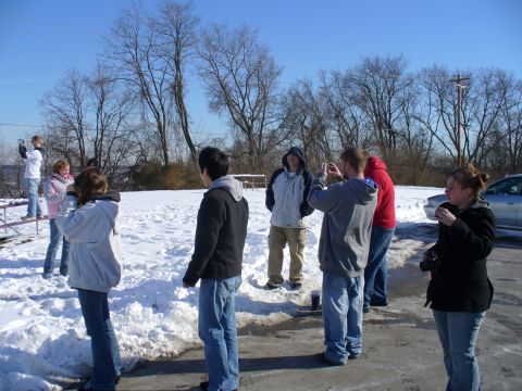 1991 Ford Probe - A group of people stand around in a snowy outdoor area on a clear day.
