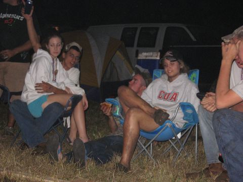 1974 Ford F-100 - A 1973 Ford F-100 truck is visible behind a campsite scene with people sitting in chairs.