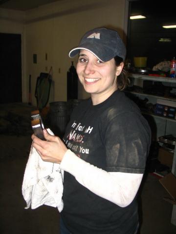 1995 Ford Bronco - A woman smiles while holding a brush and a rag, with a workshop environment in the background.