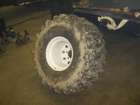 1986 Ford Ranger - A large, mud-caked tire and wheel assembly is shown in a workshop setting.