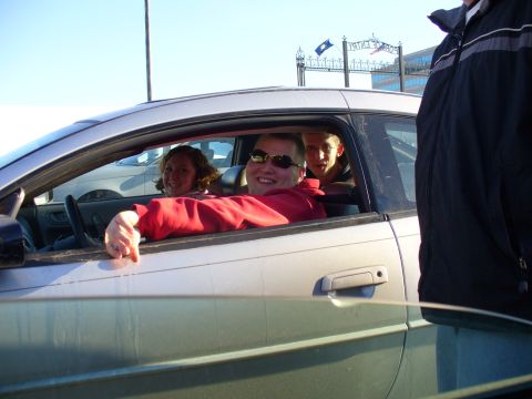 1991 Ford Probe - Three people are inside a silver car, with the driver's side door open and a person leaning out.
