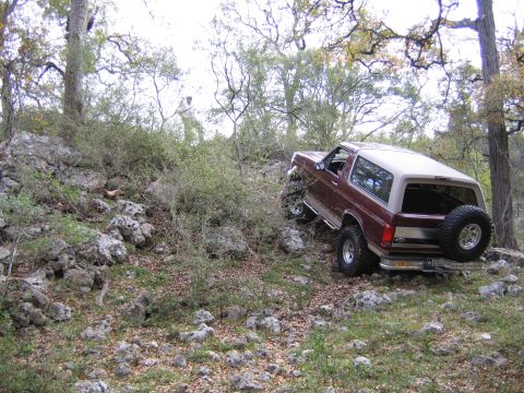 1996 Ford Bronco - Ford Bronco tackles a challenging rocky trail in a wooded area.