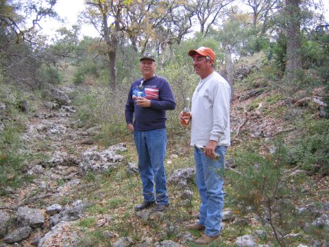 1996 Ford Bronco - Two men stand in a wooded area, one holding a drink and the other a bottle.