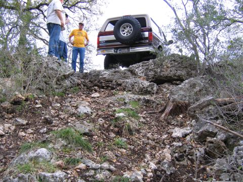 1996 Ford Bronco - Ford Bronco navigates a challenging rocky terrain with onlookers present.