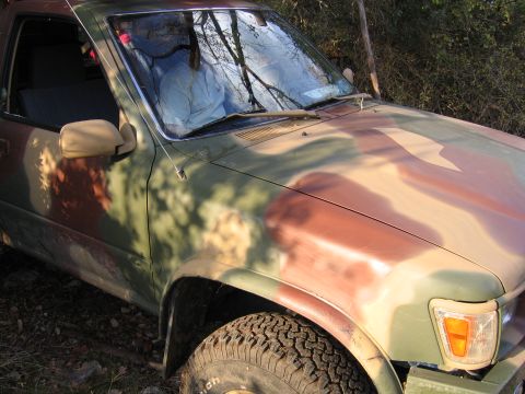 1996 Ford Bronco - This Toyota 4Runner is painted in a camouflage pattern and is parked outdoors.