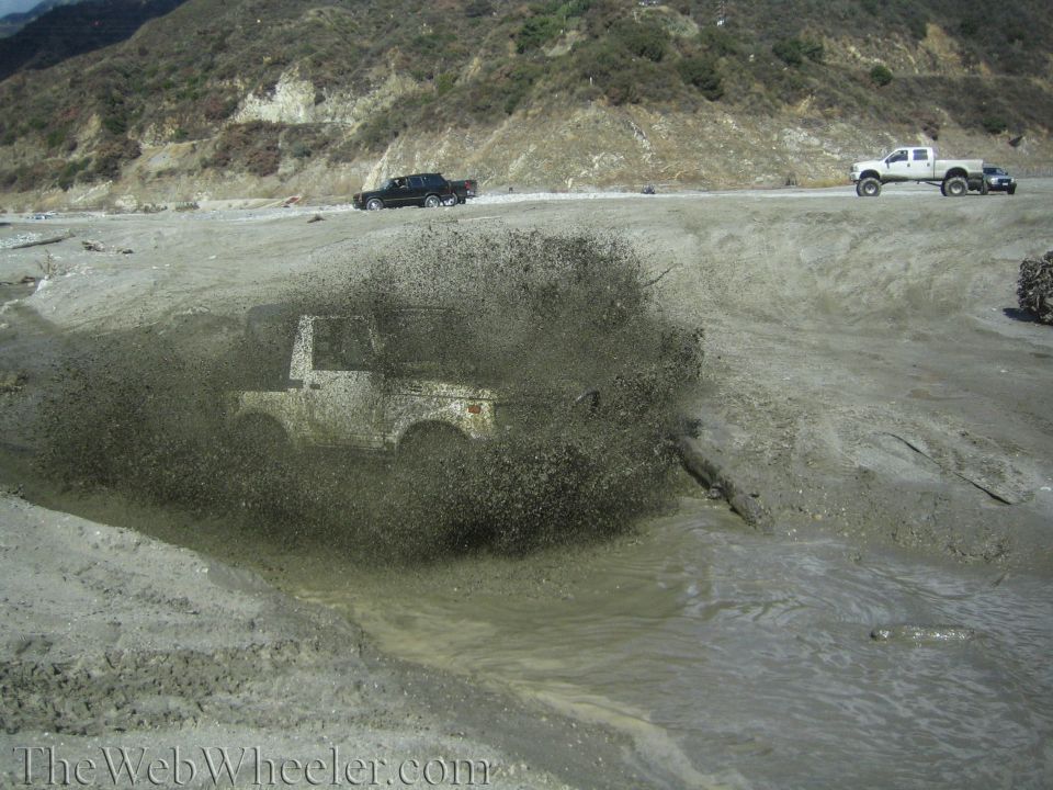 1987 Suzuki Samurai splashing through mud
