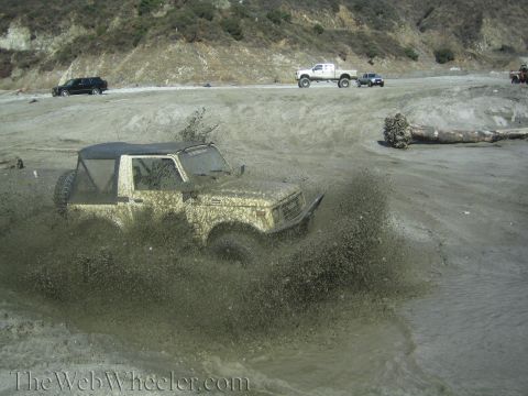 1987 Suzuki Samurai - Off-roading in a Suzuki Samurai, kicking up a large mud spray.
