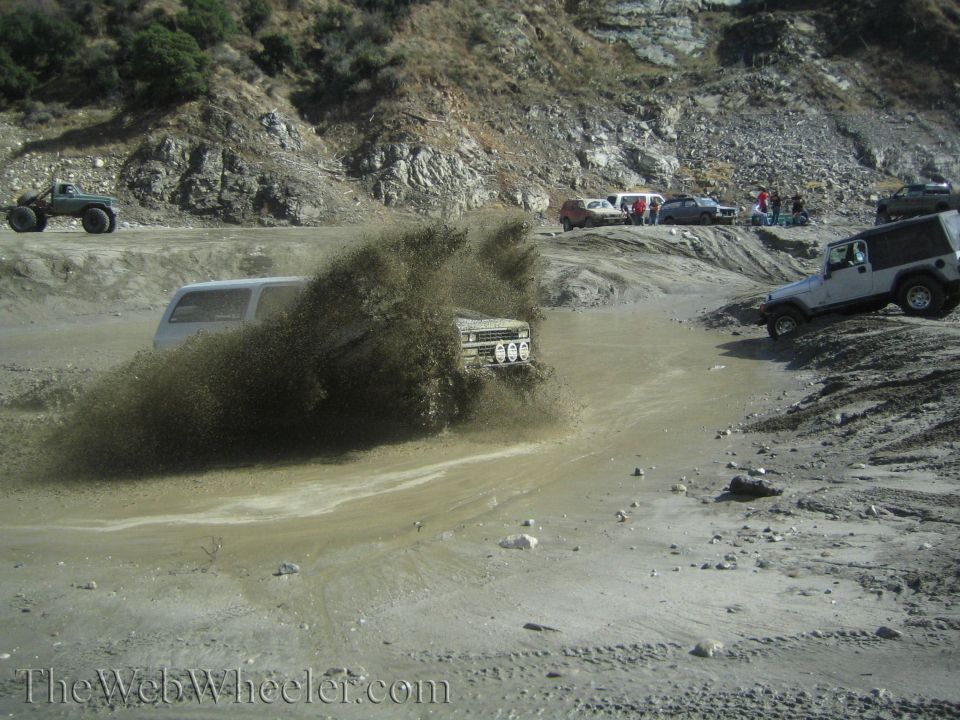 Off-road vehicles splashing through mud during an event