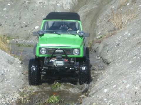 1987 Suzuki Samurai - Green 1987 Suzuki Samurai navigates a rocky stream bed.