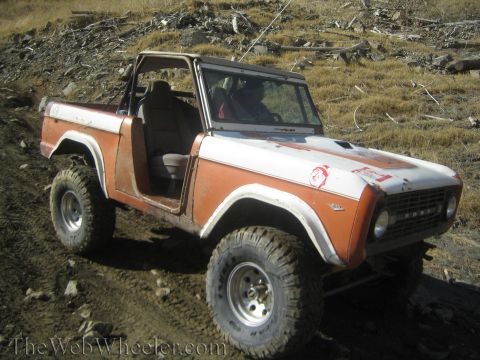 1987 Suzuki Samurai - This modified Ford Bronco is seen off-road, custom paint and large tires.