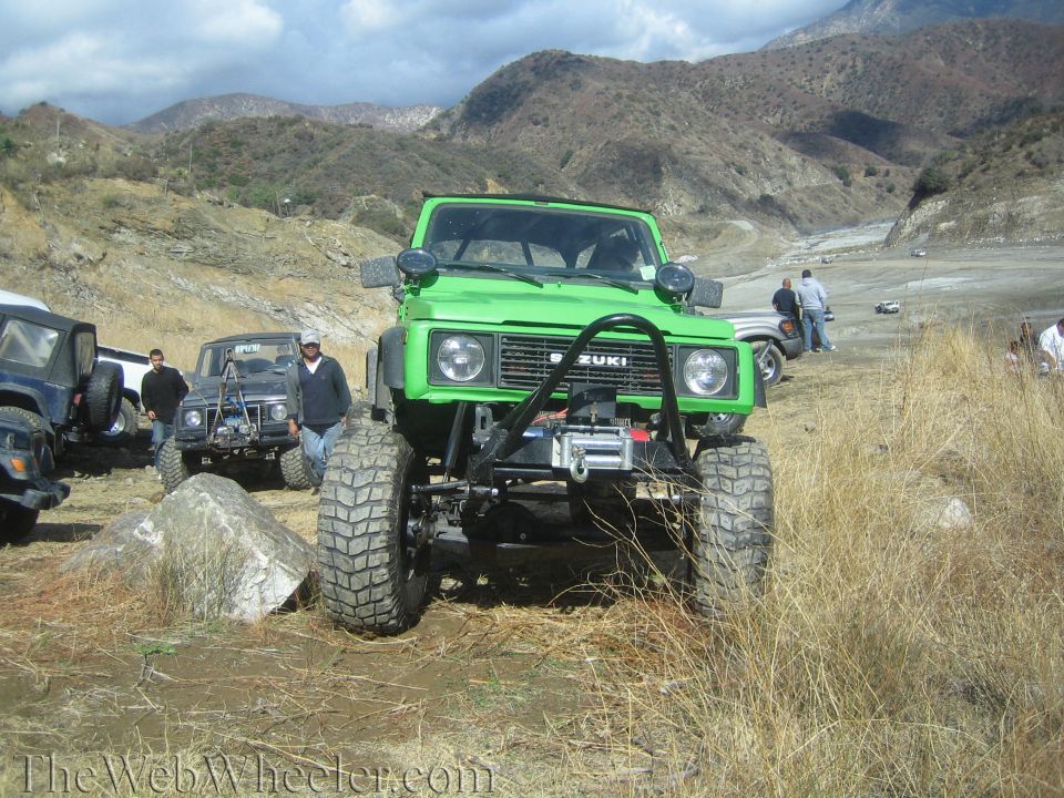 Green 1987 Suzuki Samurai with winch and off-road tires