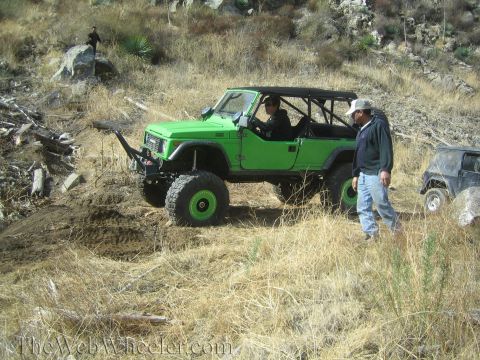 1987 Suzuki Samurai - A modified 1987 Suzuki Samurai navigates a dry, hilly terrain with another vehicle visible in the background.