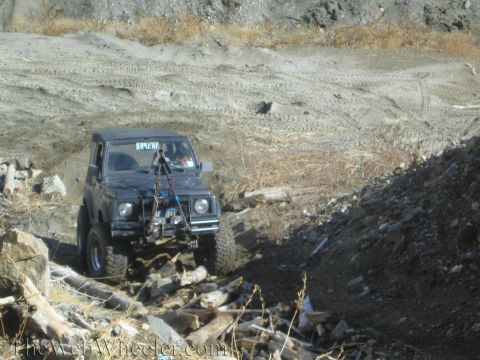 1987 Suzuki Samurai - A Suzuki Samurai navigates a rocky, off-road path with a winch attached to the front.