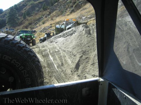 1987 Suzuki Samurai - Several off-road vehicles navigate a steep, sandy incline with visible tire tracks.