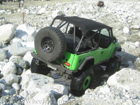 1987 Suzuki Samurai - A modified 1987 Suzuki Samurai navigates a rocky stream bed, with another vehicle visible in the distance.