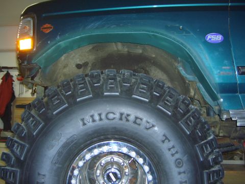 1996 Ford Bronco - Close-up of a teal SUV's fender and a large Mickey Thompson off-road tire, an FSB badge.