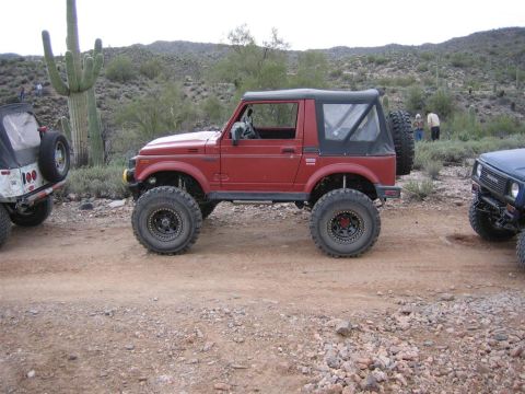 1987 Suzuki Samurai - Modified Suzuki Samurai on a desert trail with other off-road vehicles present.