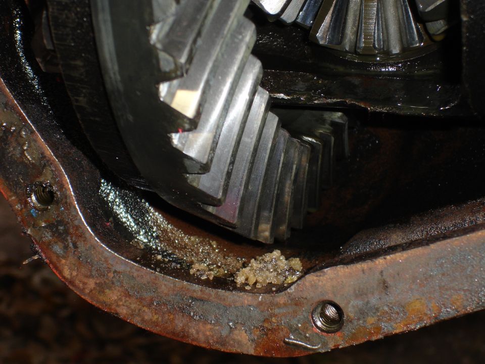 close-up of differential gears with chunky debris on the housing