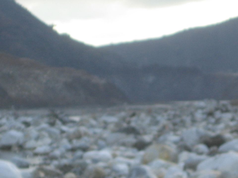 Rocky ground with mountains under a cloudy sky