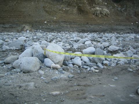 1987 Suzuki Samurai - Caution tape cordons off a rocky area with a dirt embankment, suggesting a restricted zone.