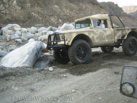 1987 Suzuki Samurai - This Jeep M715 is navigating a rocky, off-road terrain.