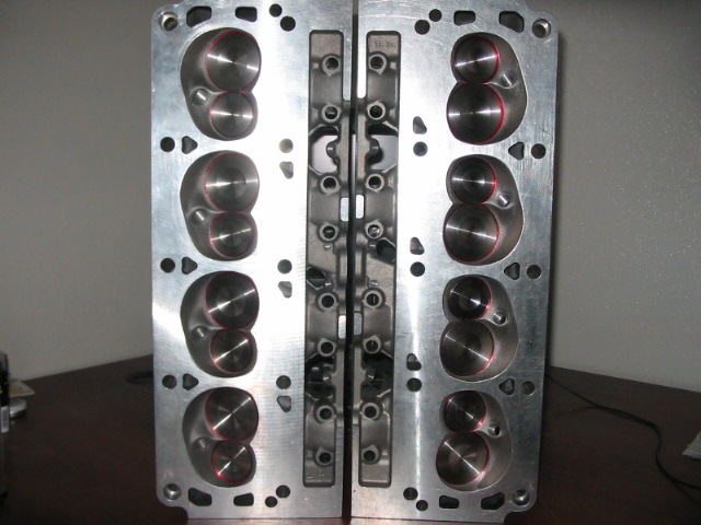 Pair of aluminum engine cylinder heads with intake and exhaust ports visible