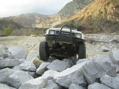 1987 Suzuki Samurai - This Suzuki Samurai is navigating a rocky terrain, its off-road capabilities.