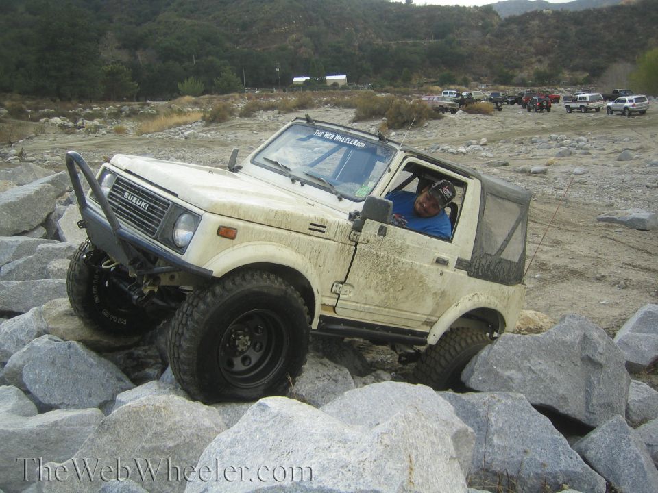 1987 Suzuki Samurai navigating a rocky trail with a driver inside