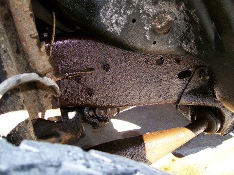 1992 Ford Bronco - Close-up view of the vehicle's frame and suspension components, showing signs of oil and wear.