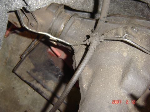 1993 Ford Bronco - Underside view of vehicle transmission components and brake lines.