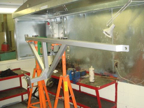 1996 Ford Bronco - A metal frame assembly is supported by jack stands in a workshop environment.