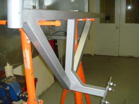 1996 Ford Bronco - A metal frame assembly, possibly a trailer hitch component, is shown supported by orange stands and a vise.