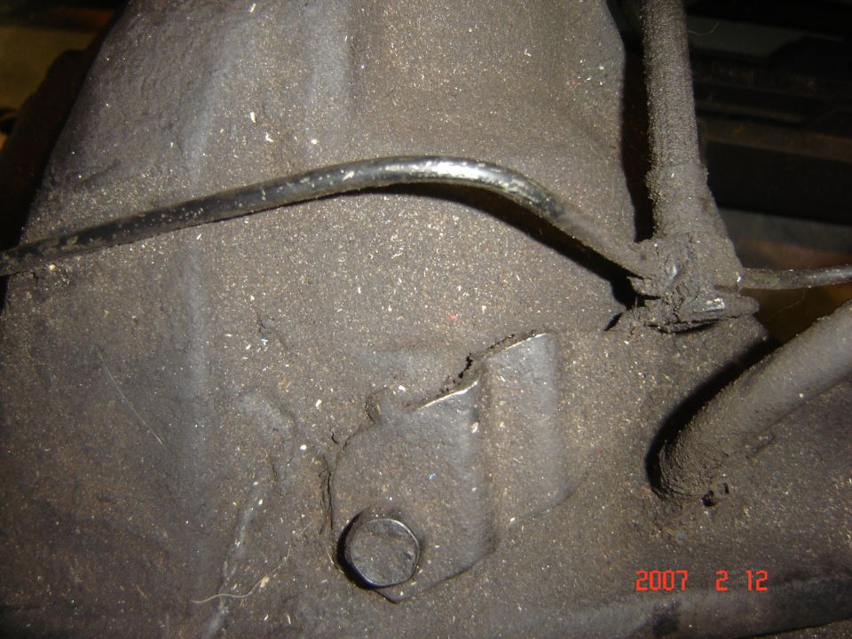 Close-up of dirty transmission housing with metal line