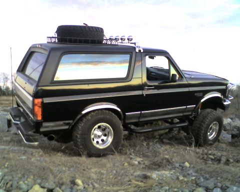 1995 Ford Bronco - This black Ford Bronco, likely from the early to mid-1990s, is equipped with off-road modifications.