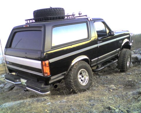 1995 Ford Bronco - This 1995 Ford Bronco is equipped with a roof rack and spare tire, seen off-road.