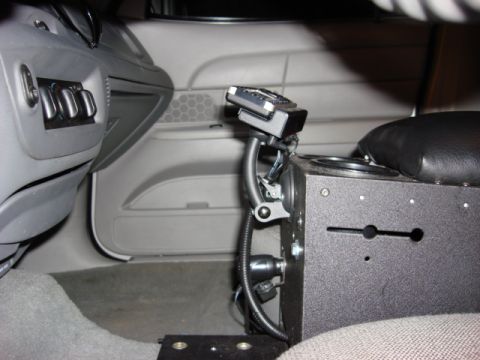 2003 Ford Crown Victoria - Interior view of a 2003 Ford Crown Victoria's center console, showing aftermarket radio equipment and cup holders.