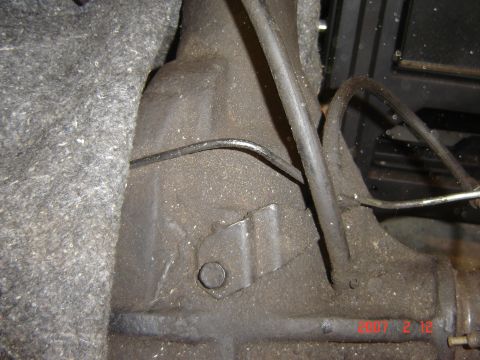 1993 Ford Bronco - Detail shot of a rear axle housing and brake line assembly, likely from underneath a vehicle.
