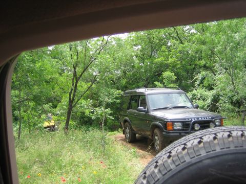 1996 Ford Bronco - Land Rover Discovery parked off-road, with another vehicle in the distance.