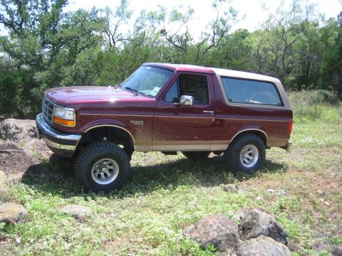 1996 Ford Bronco - This Ford Bronco is shown off-road with a two-tone paint scheme and lifted suspension.
