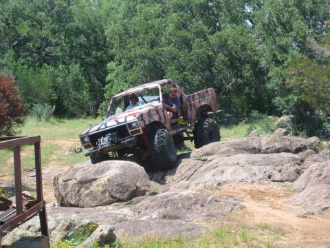 1996 Ford Bronco - This modified off-road vehicle is navigating a rocky terrain.