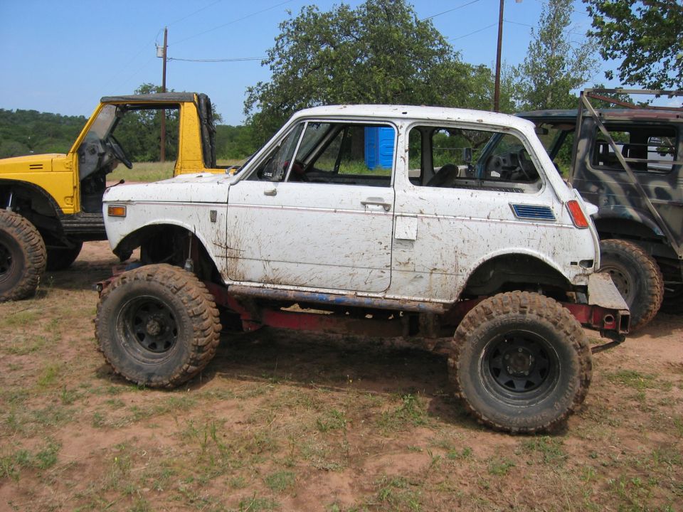 White off-road vehicle with large tires and blue accents on the side
