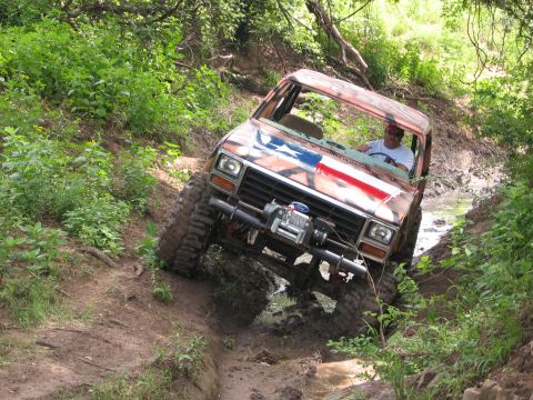 1996 Ford Bronco - This heavily modified Ford Bronco navigates a challenging off-road course in a wooded area.