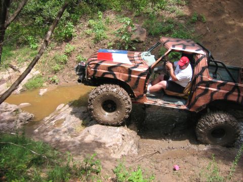 1996 Ford Bronco - This 1996 Ford Bronco navigates a muddy off-road trail with water obstacles.